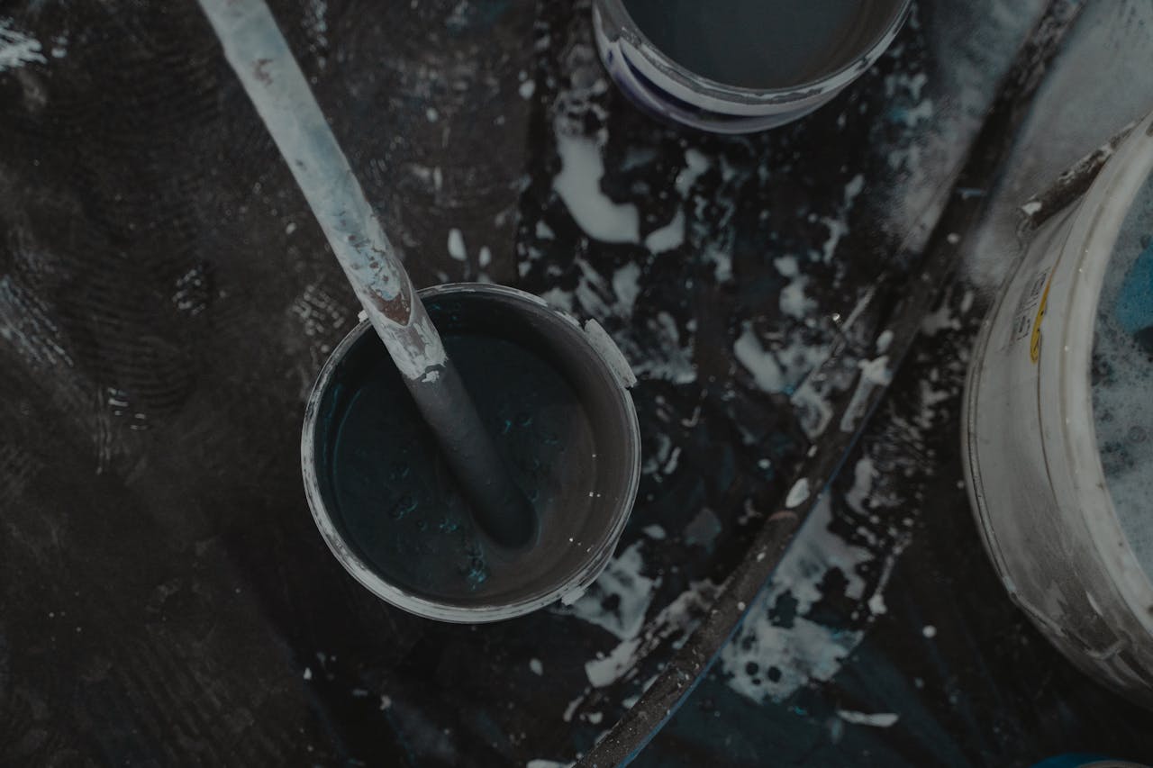 Aerial shot of paint buckets and tools on a construction site, showcasing a renovation project.